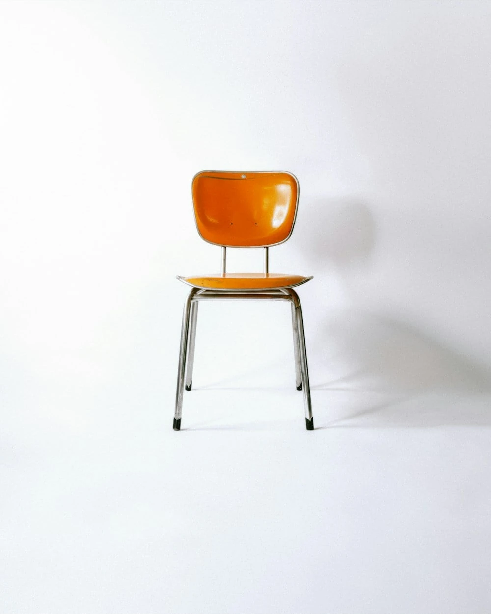 Cadeira de design laranja com estrutura cromada